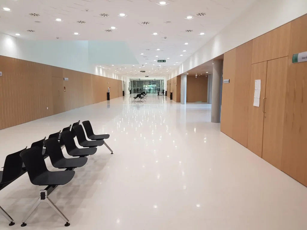 Sala con sillas modernas negras y paredes de madera clara, estilo minimalista.