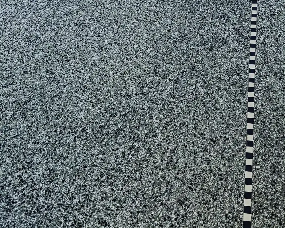 Piso de granito gris con franja decorativa en patrón damero