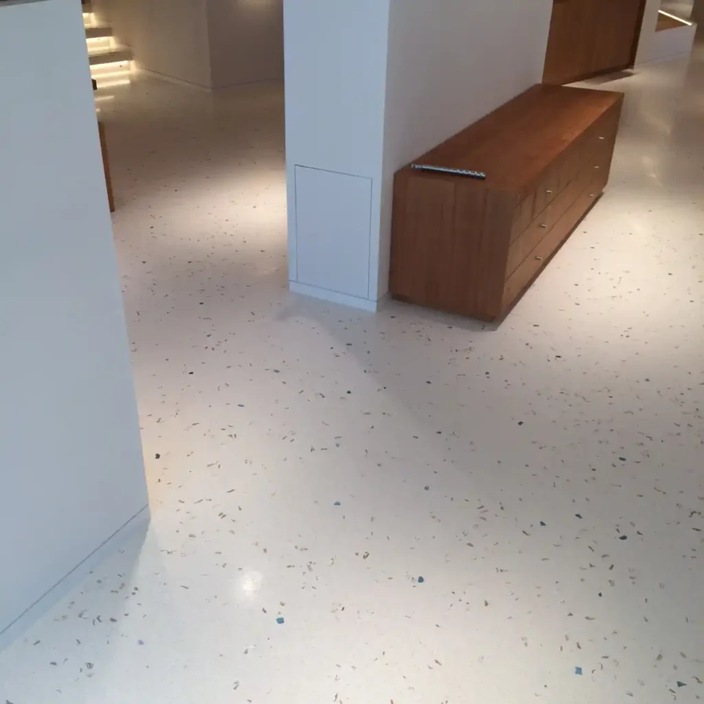 Suelo de terrazzo con detalles de piedra en tonos beige y azul, ideal para interiores modernos.