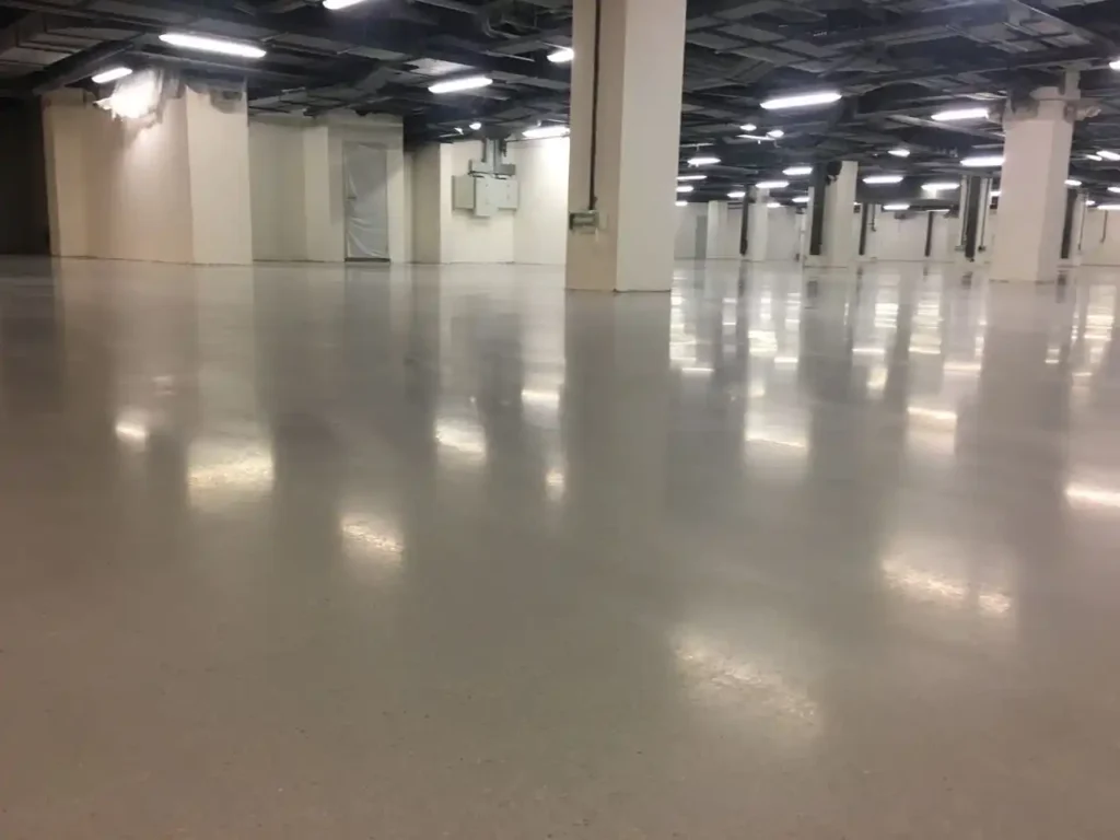 Piso de concreto pulido con iluminación reflejada en un almacén