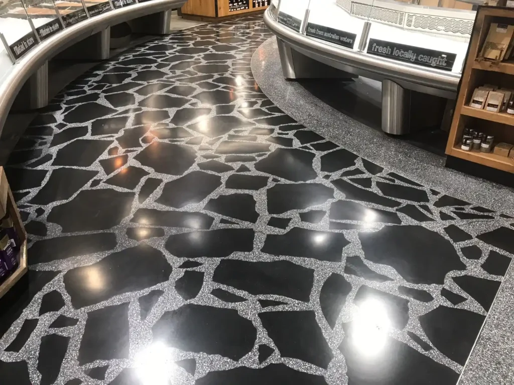 Piso negro brillante con detalles en gris, estilo de terrazzo.