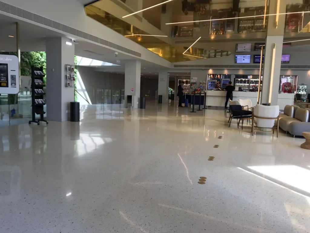 Lobby de oficina con pisos de terrazo y detalles modernos.