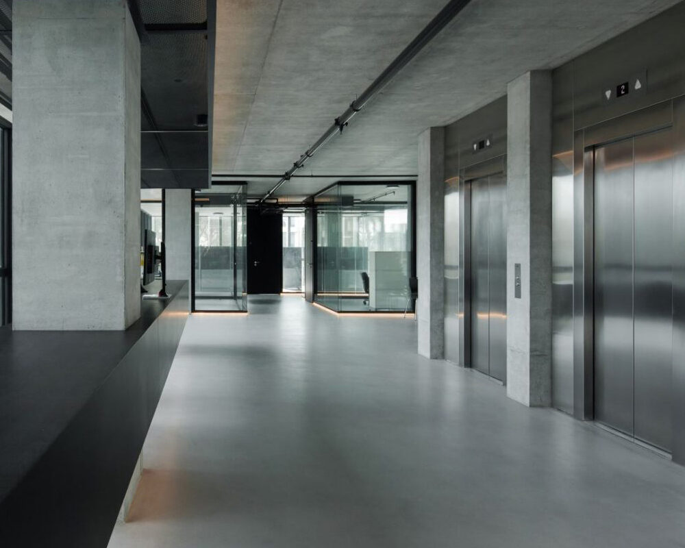 Ventanas grandes de oficina con vista hacia el patio interior, diseño moderno y minimalista.
