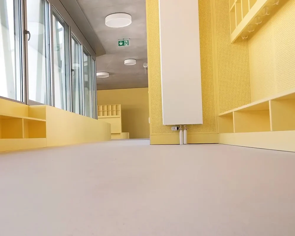Sala moderna con paredes amarillas y estanterías minimalistas, creando un ambiente luminoso.