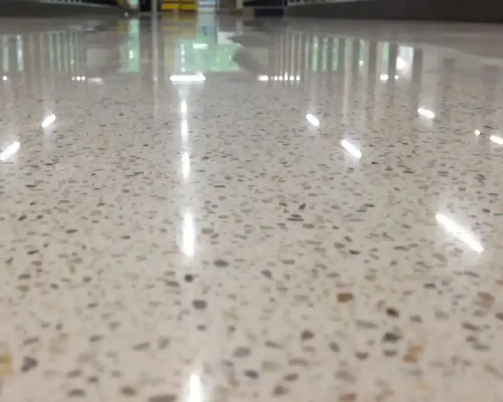 Suelo de mármol con reflejos de luz brillante en un área comercial.