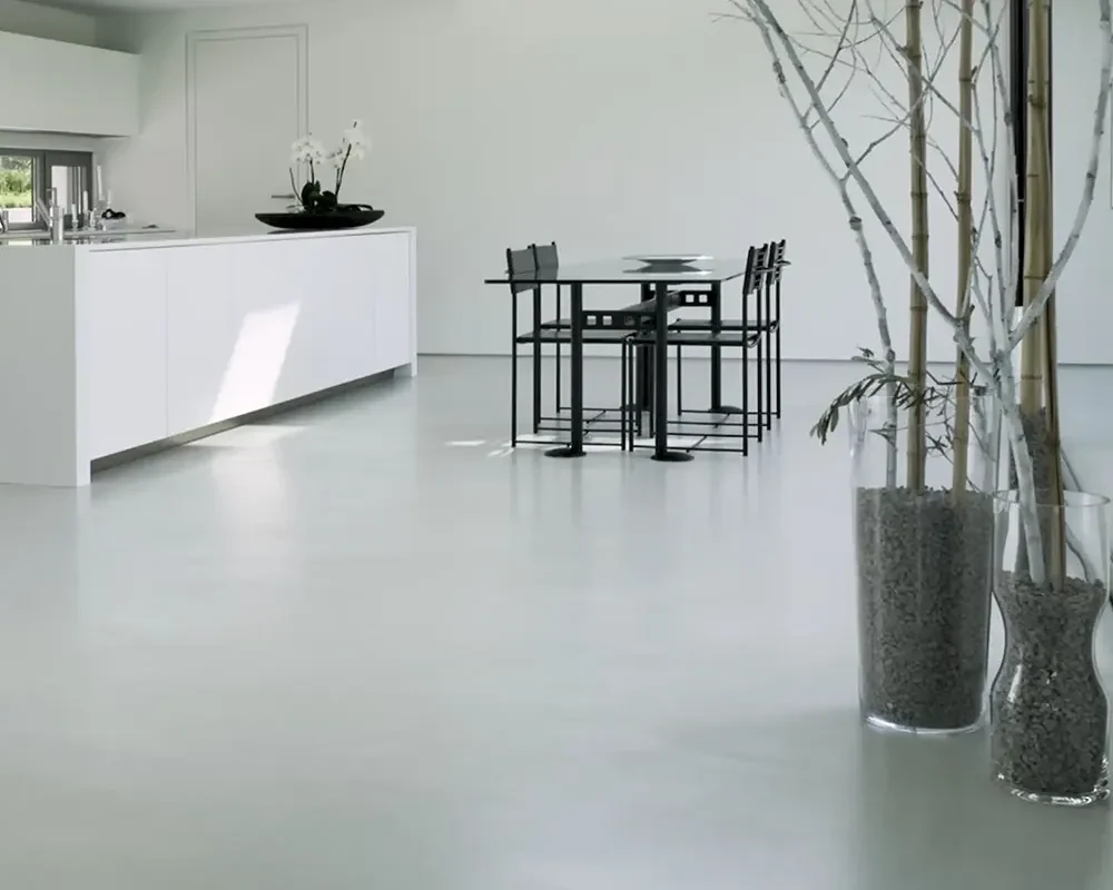 Cocina moderna minimalista con encimera blanca y paredes claras.