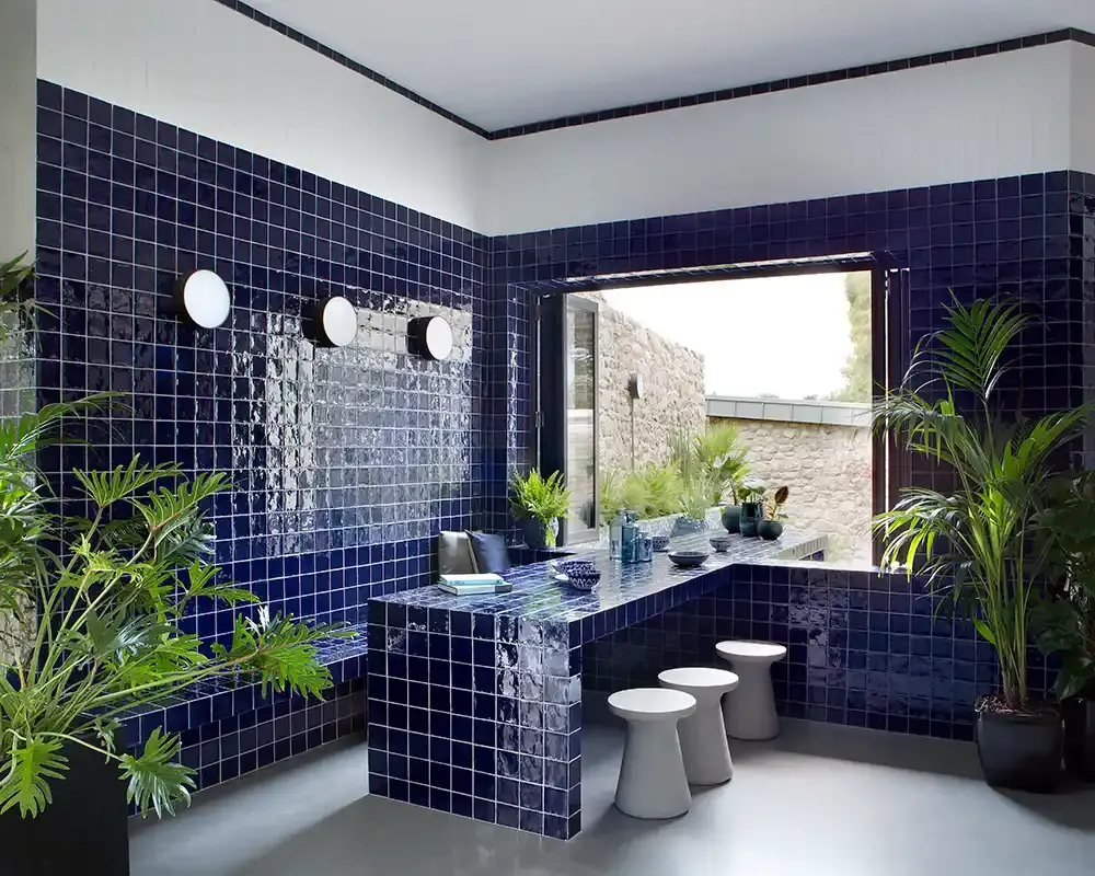 Interior moderno con azulejos azules en la pared, muebles minimalistas y luz natural en el espacio.