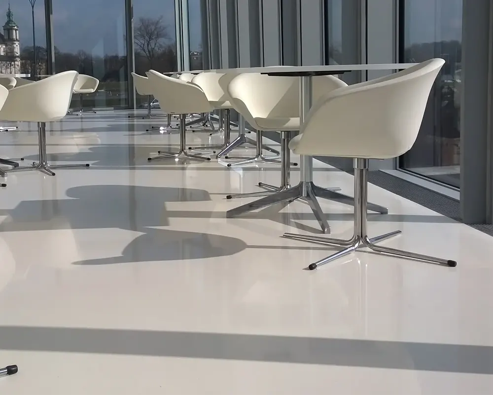 Sala moderna con sillas blancas y mesas, vista panorámica