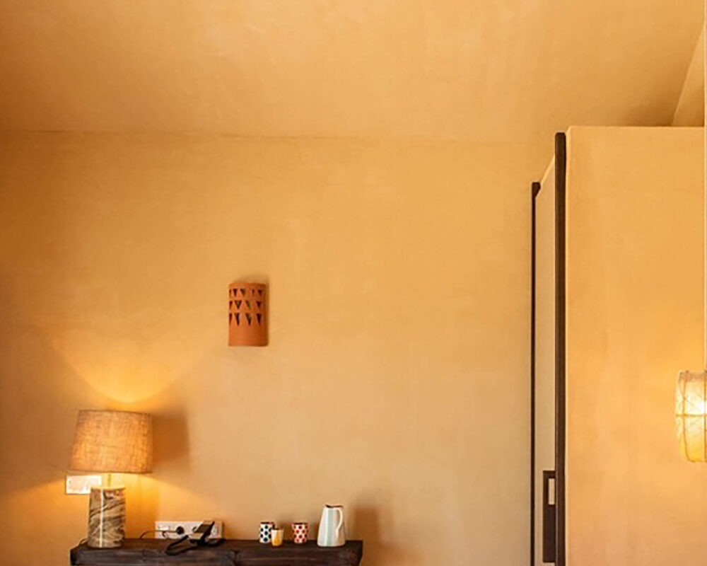 Decoración cálida en habitación con lámparas de mesa y pared de barro