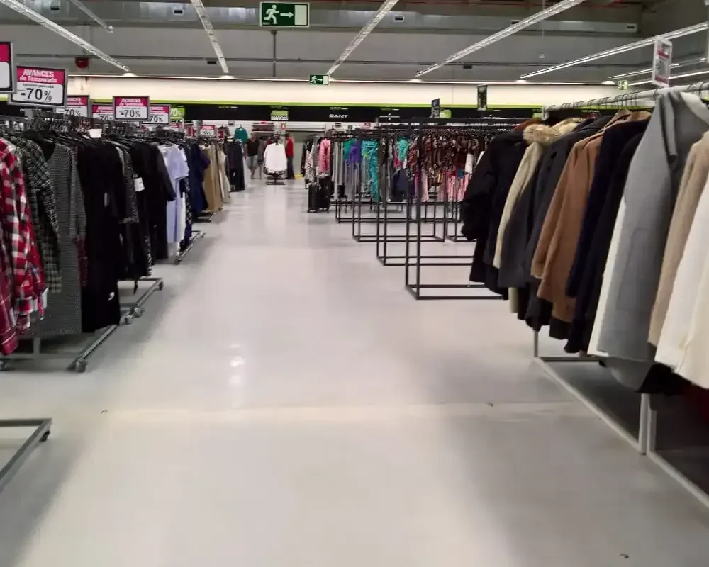 Pasillo de tienda con racks de ropa en oferta del 70%