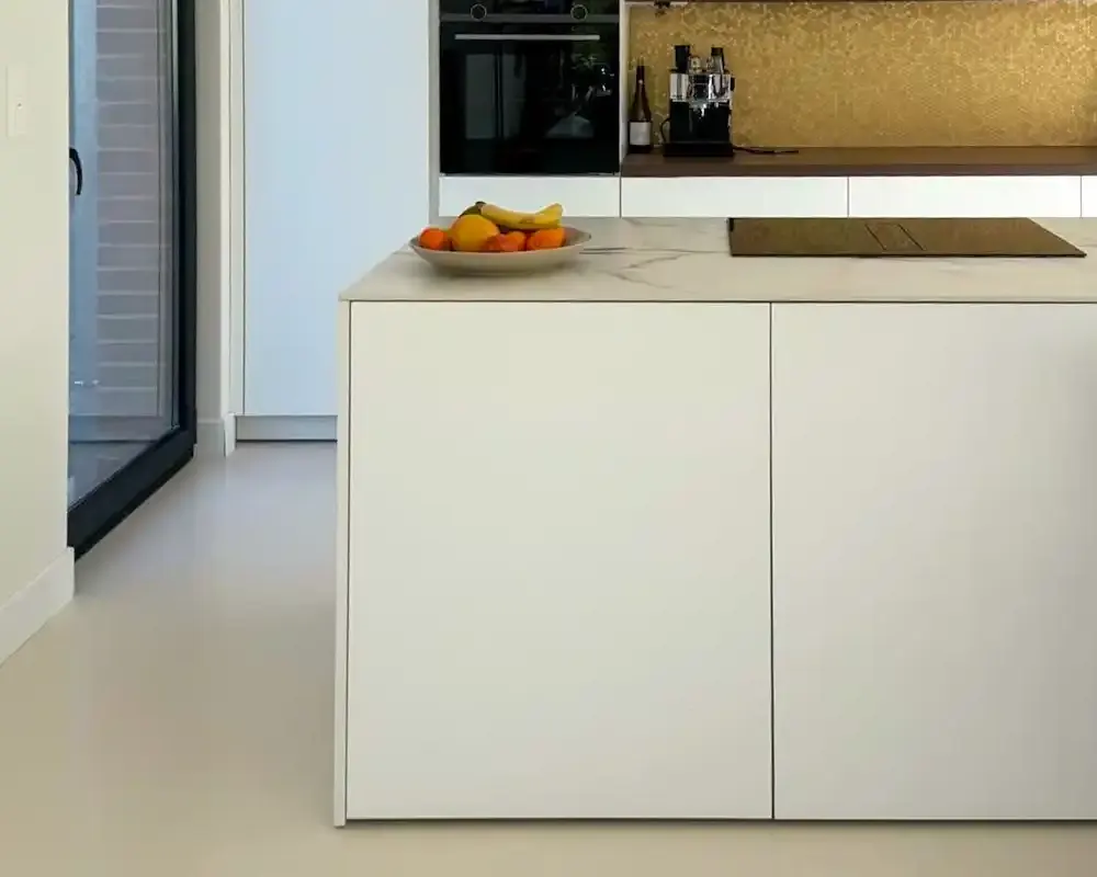 Cocina moderna con pavimento cementoso decorativo en tonos claros y muebles minimalistas.