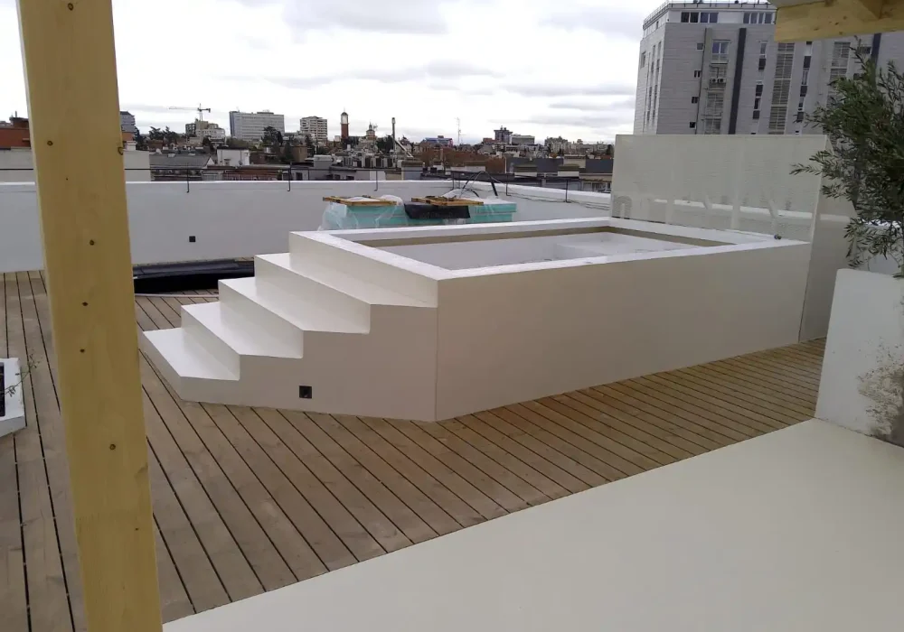 Piscina elevada en terraza moderna con deck de madera. Terraza moderna con piscina elevada de diseño minimalista y deck de madera.