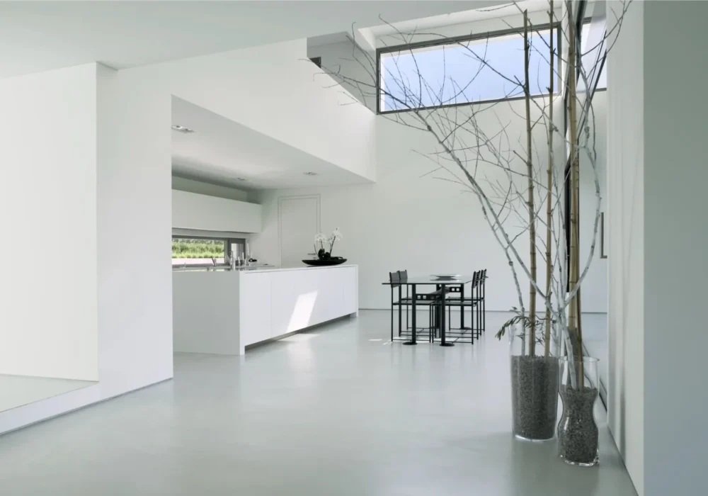 Cocina moderna minimalista con encimera blanca y paredes claras.