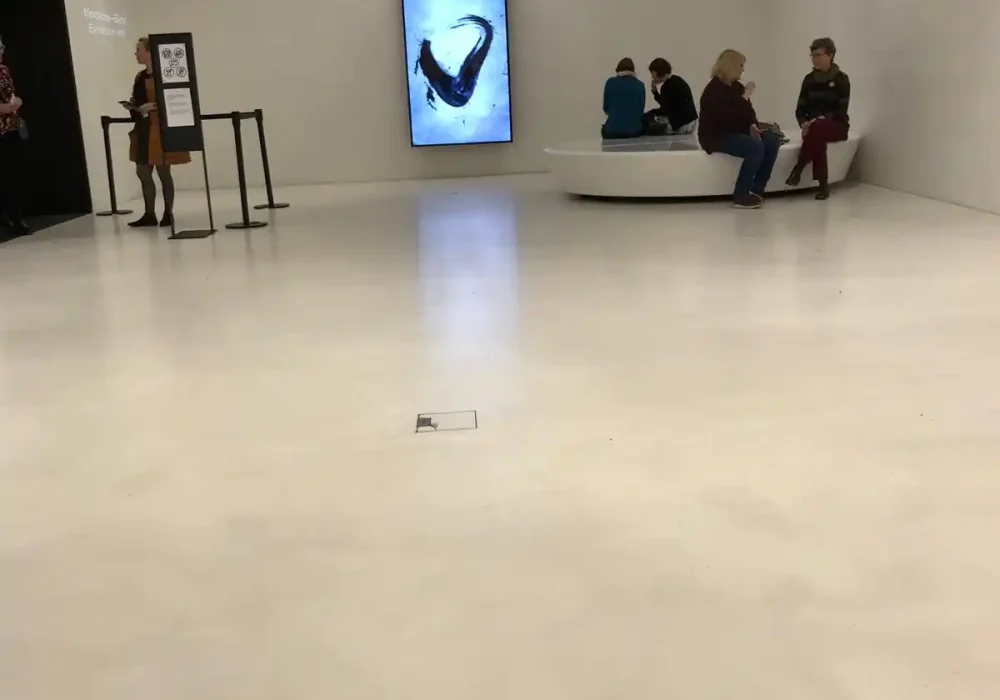 Espacio moderno de exhibición con suelos claros y pantallas digitales