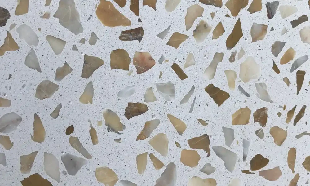 Superficie de terrazo beige con fragmentos de piedras en tonos marrones, grises y blancos