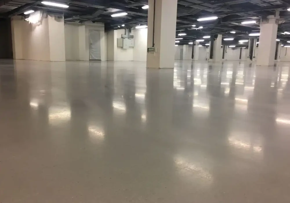 Piso de concreto pulido con iluminación reflejada en un almacén