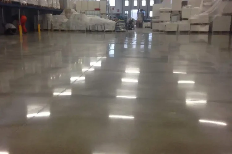 Suelo industrial pulido con reflejos de luz en almacén